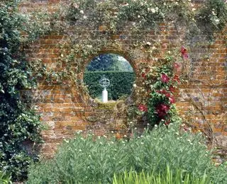 La meridiana di Polesden Lacey, Surrey, vista attraverso un portale circolare in un muro del giardino