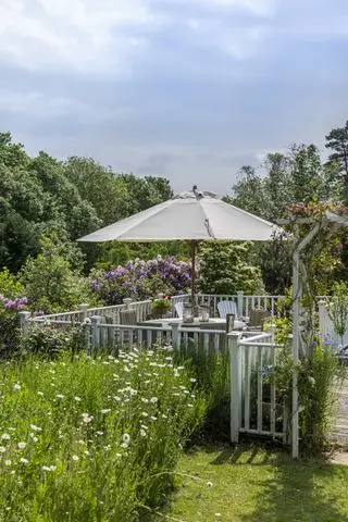 Vonkajší jedálenský kút ohraničený nízkym oplotením