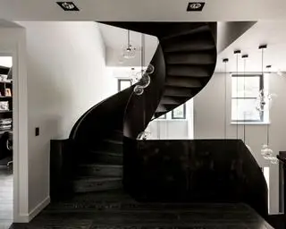Escalier noir incurvé avec éclairage suspendu