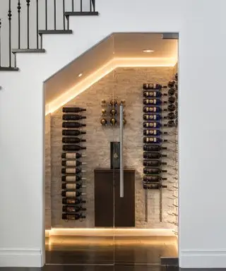 Une idée sous les escaliers avec une cave à vin éclairée par LED dans un escalier blanc moderne