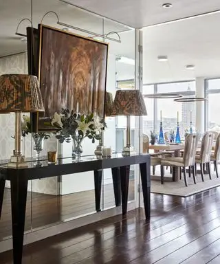 거울벽에 등을 대고 콘솔 테이블에 테이블 램프를 설치한 복도 조명 아이디어