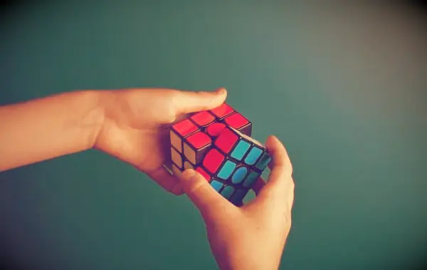 Two hands trying a to solve a Rubik