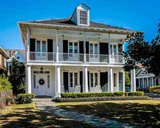 Extérieur d'une maison de style colonial français en brique blanche avec balcons et colonnes