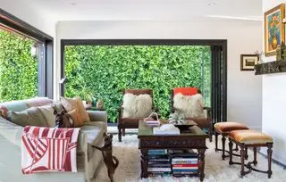 Stue med sofa og lenestoler og dører åpne utvendig