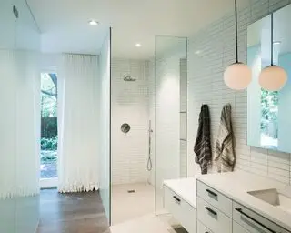 Salle de bain du sous-sol avec douche et vanité avec carrelage blanc