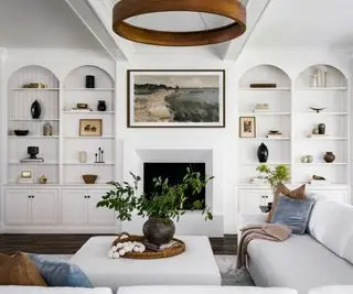 Sala com estantes simétricas, plantas e iluminação ambiente