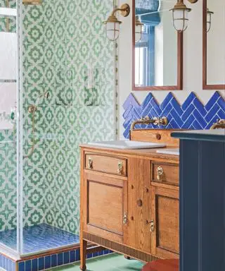 Salle de douche décorée de carrelage bleu marine et vert avec vasque en bois