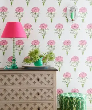 カントリーデコレーションのアイデア - トレリスチェストとグリーンとピンクのテーブルランプを備えたブロックプリントの花柄壁紙