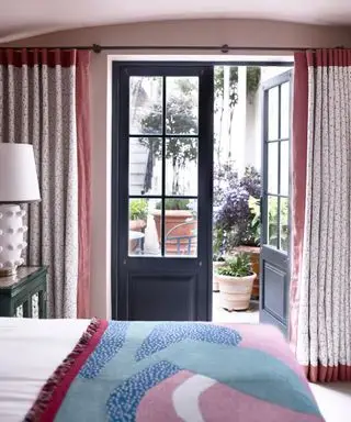 Idea de tratamiento de ventana con cortinas hasta el suelo en un dormitorio.