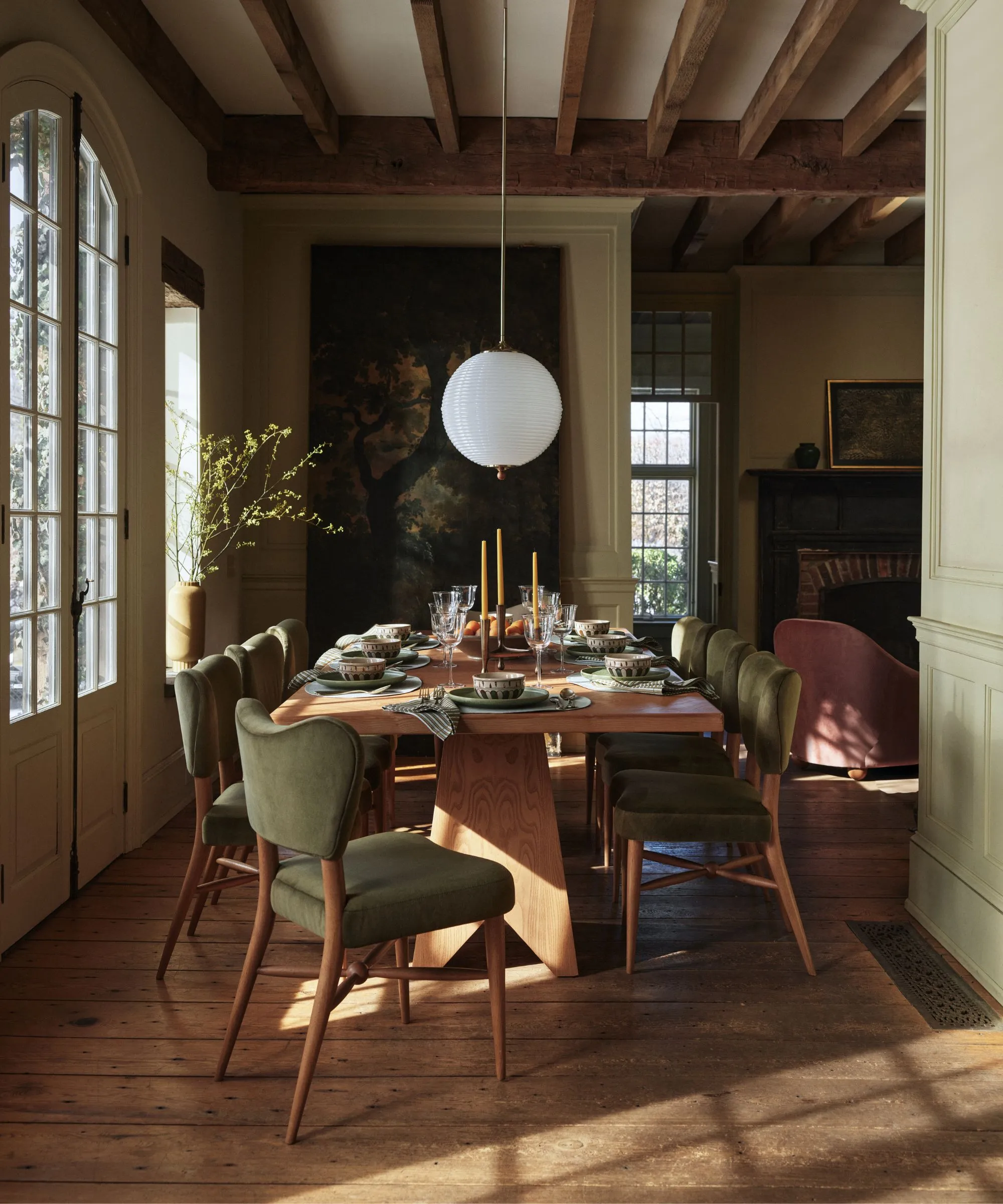 retro eklektisk jordagtig spisestue med et gobelin på væggen og grønt fløjlspolstrede spisestuestole' loading='lazy' title=