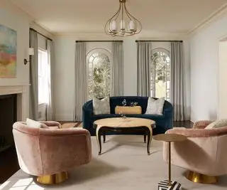 ダークグリーンのソファとピンクの椅子を備えたニュートラルなリビングルーム