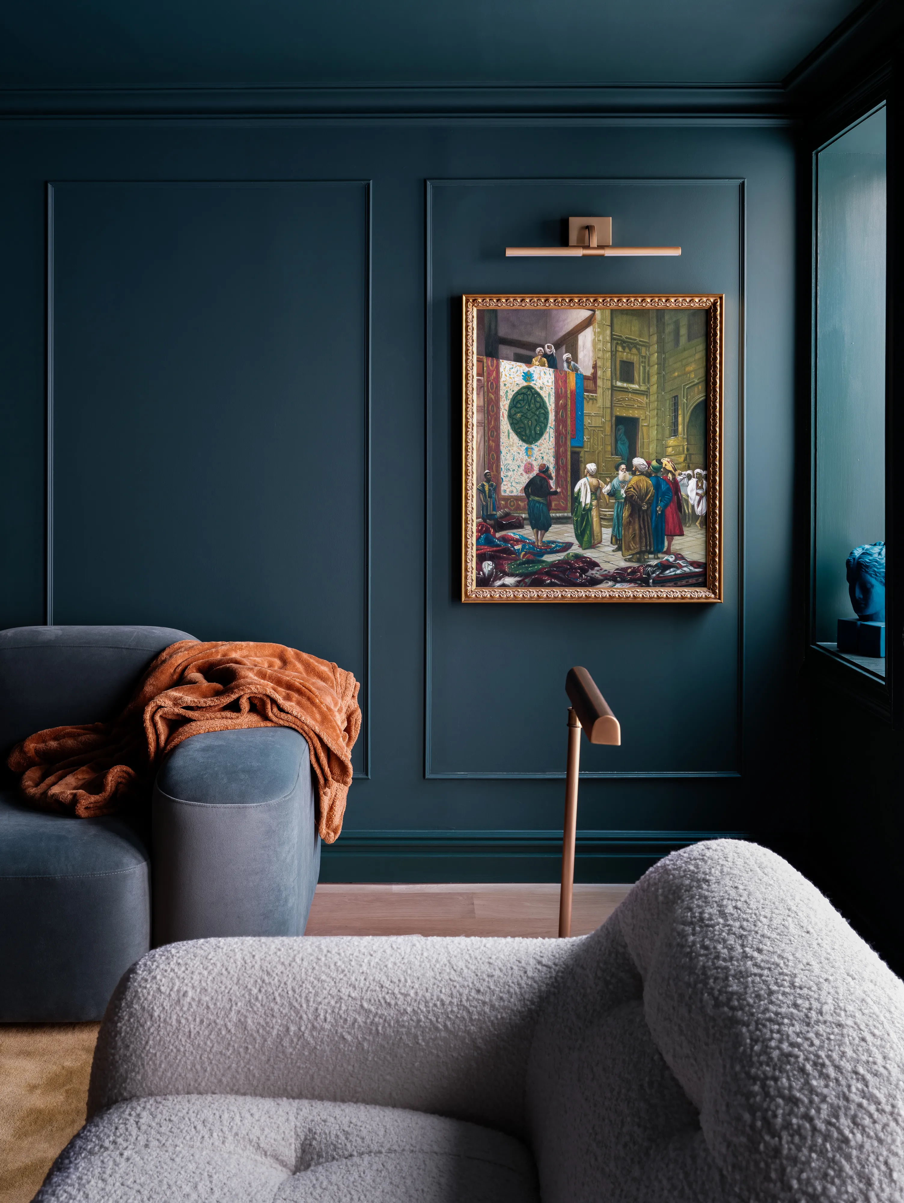 Marineblaues Wohnzimmer mit niedrigen Sofas und Wandkunst in einem kunstvollen Rahmen im antiken Stil' loading='lazy' title=