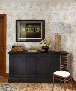 Couloir rustique dans la maison néo-Tudor des années 1920 à Seattle, table décorée avec lampe de table, œuvres d'art, fleurs, livres