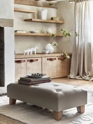 salon de ferme avec pouf, étagères en bois, tapis crème