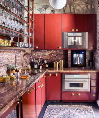 Cozinha vermelha com armários vermelhos, tapete e área de bar