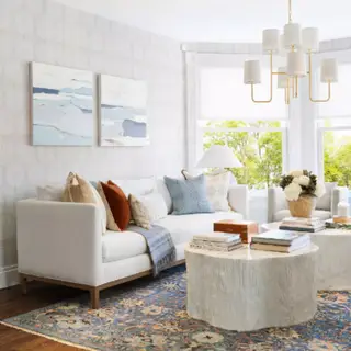 青と茶色のクッションが付いた白いソファとコーヒー テーブル。