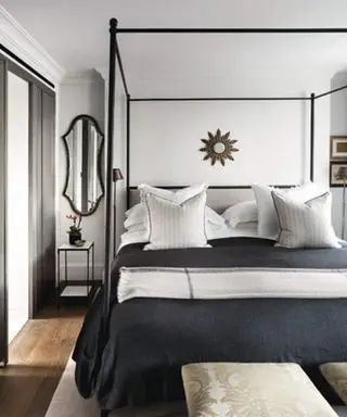 Dormitorio en blanco y negro con espejo colgado sobre mesitas de noche