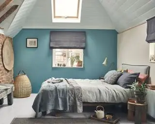 Chambre dans une maison de campagne avec une touche moderne, parquet peint en blanc, plafond lambrissé blanc, murs peints en bleu, literie et clignotants gris, paniers et accessoires tressés, cadre de lit et banc en bois rustique