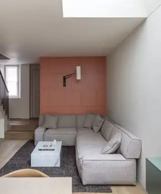 akcentujúce steny, koralovo obložená akcentačná stena s nástenným svetlom, sivý sektorový, štruktúrovaný koberec, mramorový konferenčný stolík