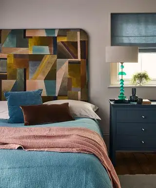 침대와 머리판, 침대 옆 탁자와 테이블 램프가 있는 침실