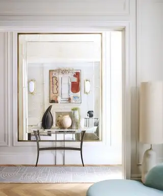 거울과 콘솔 테이블이 있고 복도가 보이는 거실