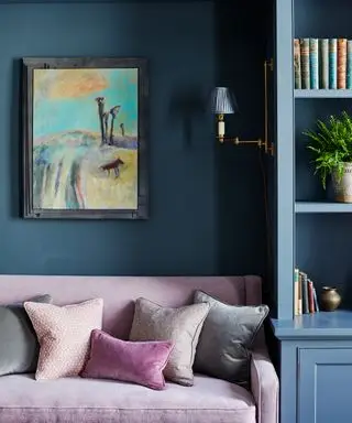 파란색 벽과 소파 옆에 있는 파란색 맞춤형 캐비닛