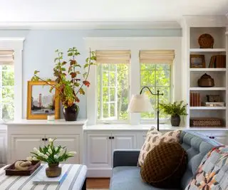 Sala de estar tradicional com prateleiras embutidas e luminária de chão grande