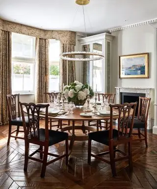 Salle à manger avec grande table ronde et plancher de bois