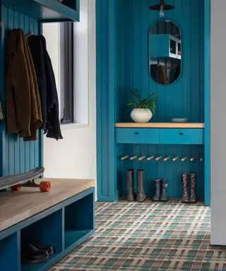 Bootroom bleu avec armoires peintes, tapis tartan bleu, chaussures et manteaux rangés