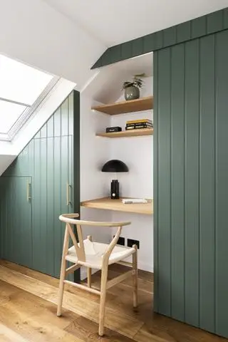 Bureau à domicile avec placard loft et porte coulissante à panneaux verts, étagères en bois, chaise en bois, parquet, murs blancs