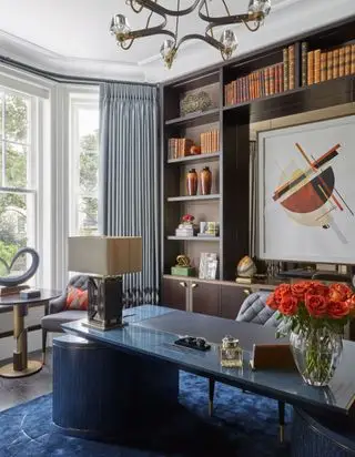 Bureau en pierre polie bleue, tapis bleu foncé avec lignes dorées, poignées dorées sur les armoires et pieds de chaise