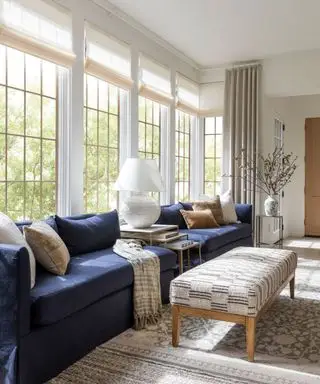 véranda avec de grandes fenêtres et un canapé bleu marine