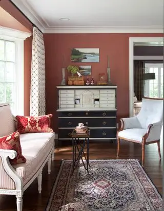 Rideaux à motifs dans le salon en terre cuite avec fauteuil décoratif par fenêtre et tapis ancien au sol