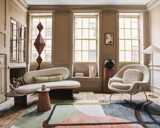 밝은 갈색 벽, 대형 창문 및 현대적인 가구를 갖춘 넓은 거실