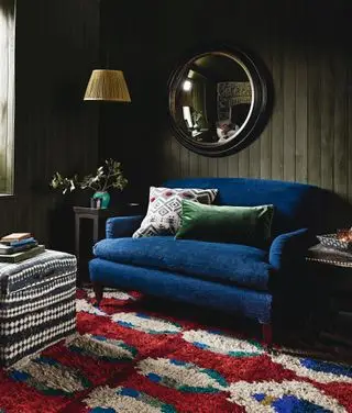 stue med grønnmalt shiplap, blå sofa, rød, blå og hvit sofa, puff, bordlamper, pendellys, speil