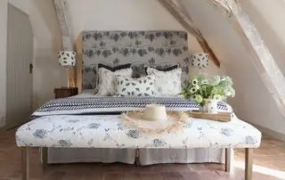 Chambre de campagne française avec banquette et lit recouverts de tissu bleu et blanc