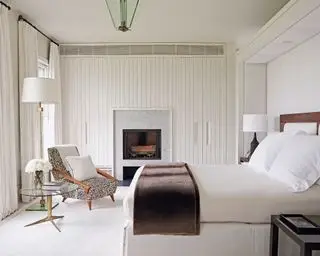 Chambre lambrissée blanche avec panneaux blancs et cheminée