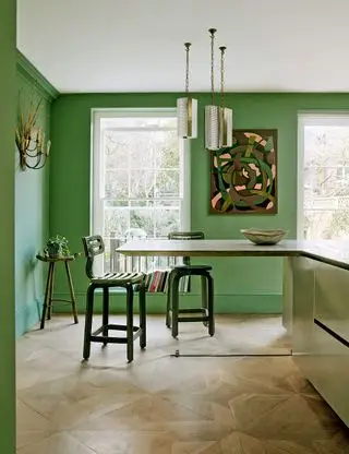 Cuisine-salle à manger verte avec murs peints en vert et table en forme de L