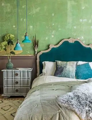 Chambre verte avec tête de lit et coussins bleus