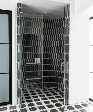 Vintage-Badezimmer mit senffarbener Wandverkleidung, geometrischen Bodenfliesen und Messingarmaturen für Art-Deco-Atmosphäre