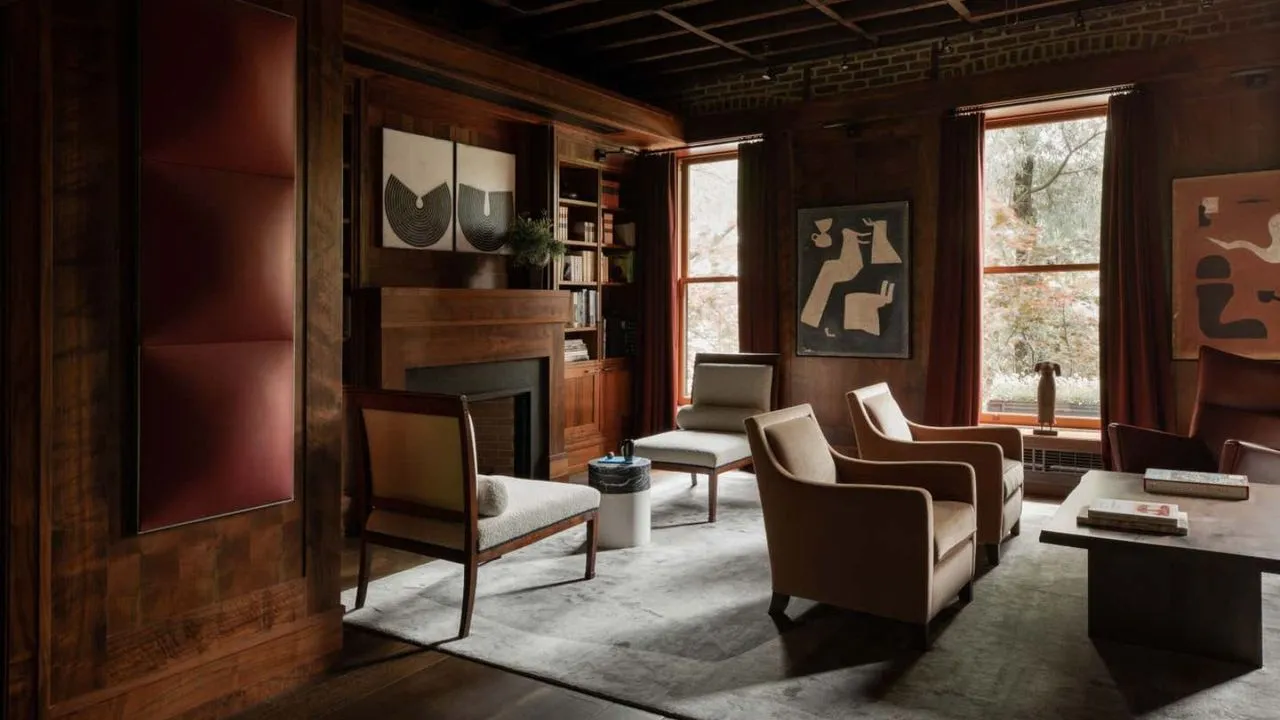 Obývacia izba vymaľovaná v sýtočervenej farbe s dvoma oddelenými priestormi na sedenie. Drevené obklady na stenách.' loading='lazy' title=