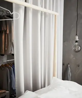 Chambre moderne avec placard ouvert, recouverte de rideau blanc, lit avec draps blancs