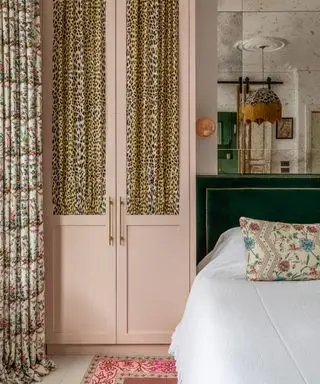 Chambre richement texturée avec armoire rose avec rideaux à imprimé léopard, rideaux de fenêtre fleuris, tête de lit en velours vert, mur en miroir,