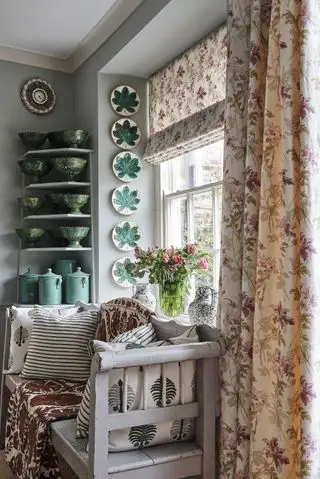 salon avec store et rideaux assortis, murs gris, banquette peinte et plaques au mur