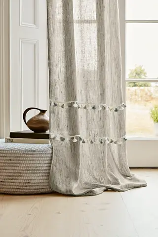 Salle à manger peinte en gris avec chaise en bois noir, chaises assorties avec sièges en cuir, tapis gris, rideaux orange vif, grandes œuvres d'art colorées au mur