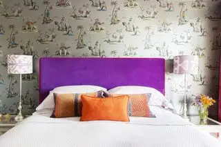 chambre avec papier peint et tête de lit en velours violet