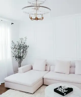 Un salon monochrome avec un canapé blanc