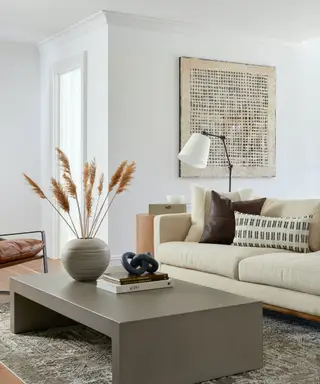 Un salon avec un canapé blanc et une table basse marron.