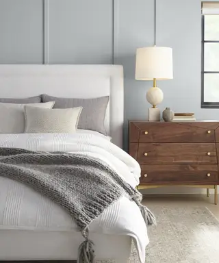 Šedá ložnice s dřevěným odkládacím stolkem