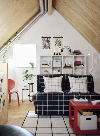 dormitorio juvenil/sala de juegos con sofá, estanterías, silla, mesa de café roja, silla roja, lámpara de pie y estantería